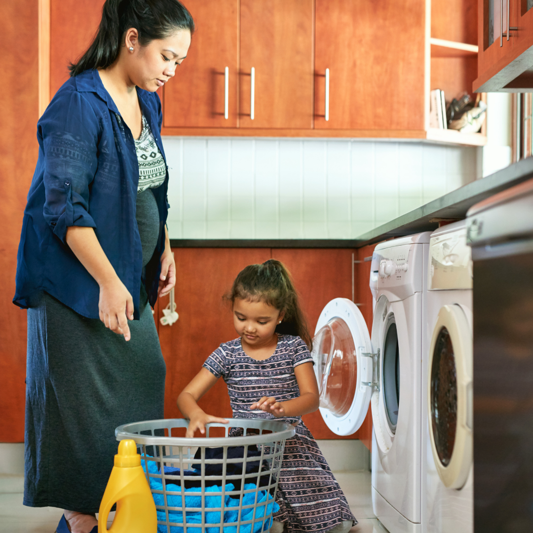 little girl helping her mom do laundry