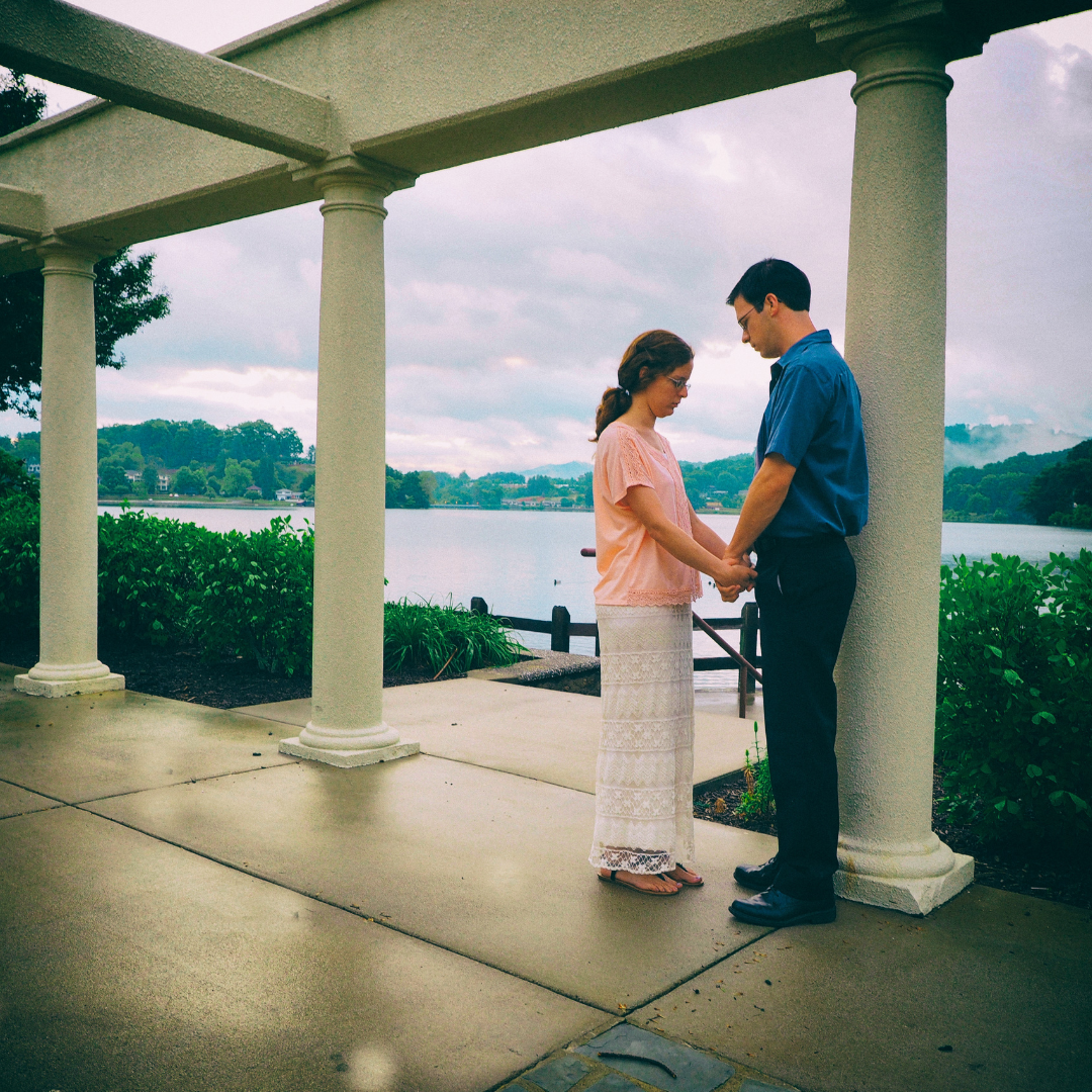 couple praying together in a gazebo