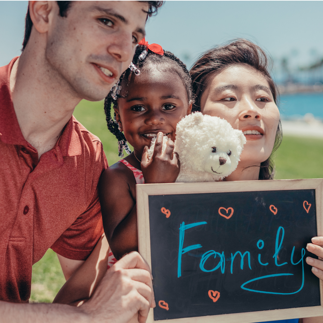 parents and small child with a sign that says "family"