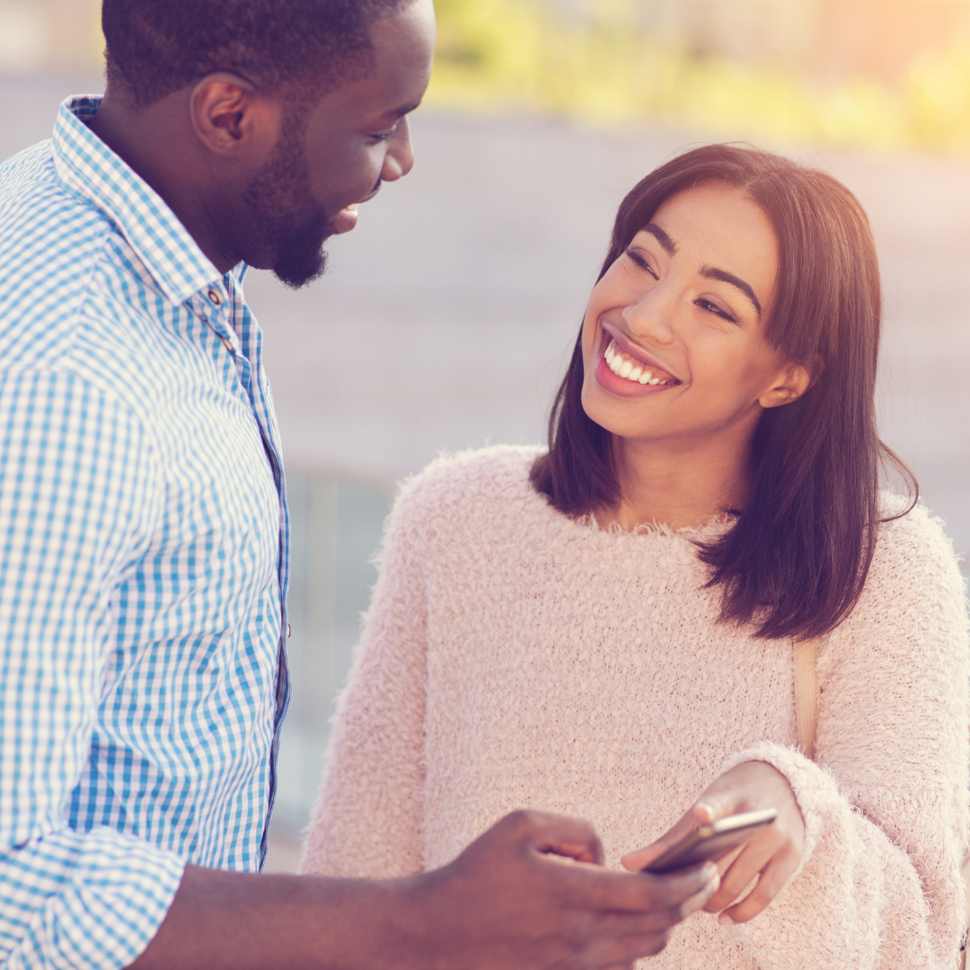 couple looking at each other and holding a cell phone