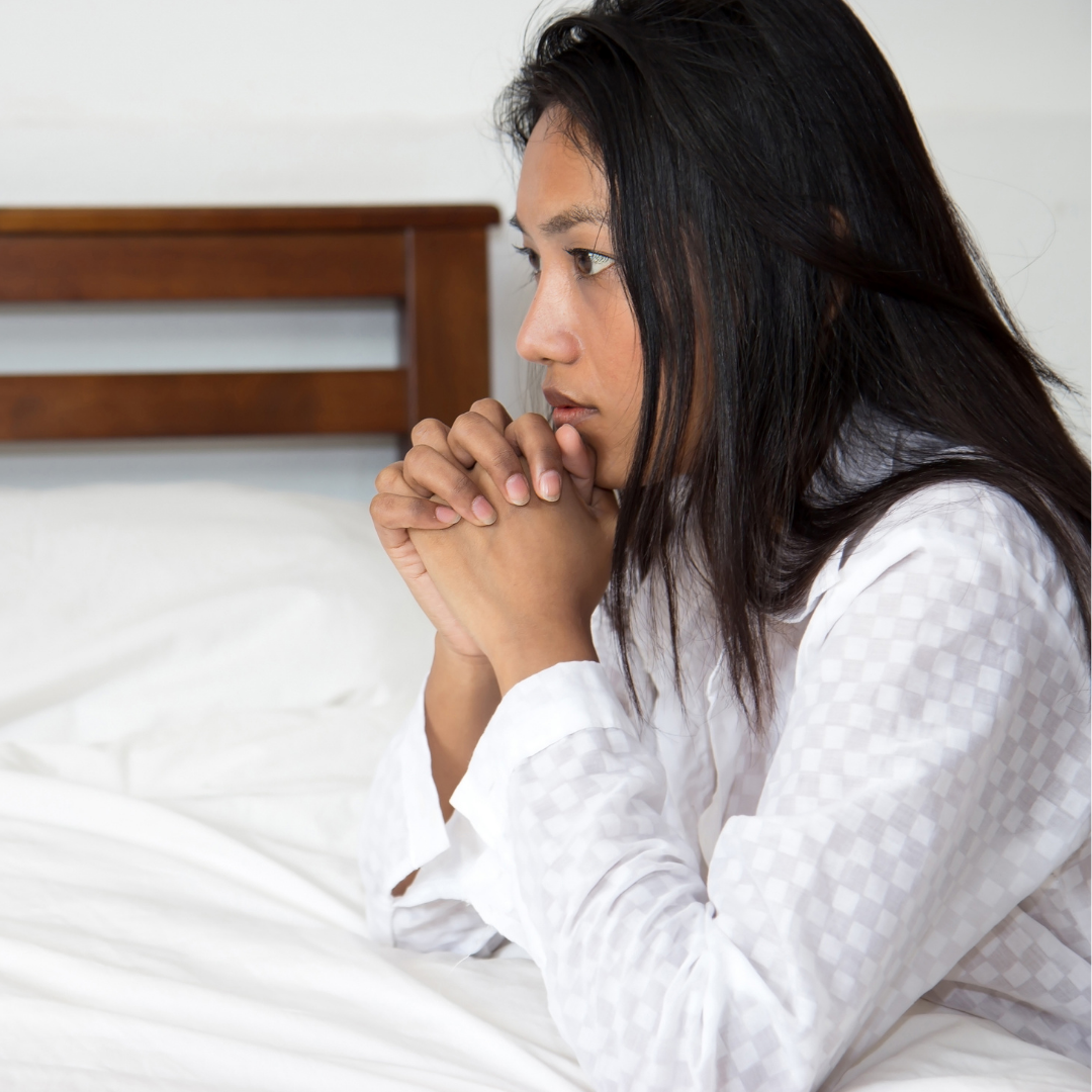 woman praying beside the bed