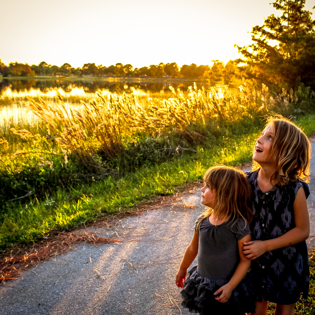 2 little girls looking at a sunny field