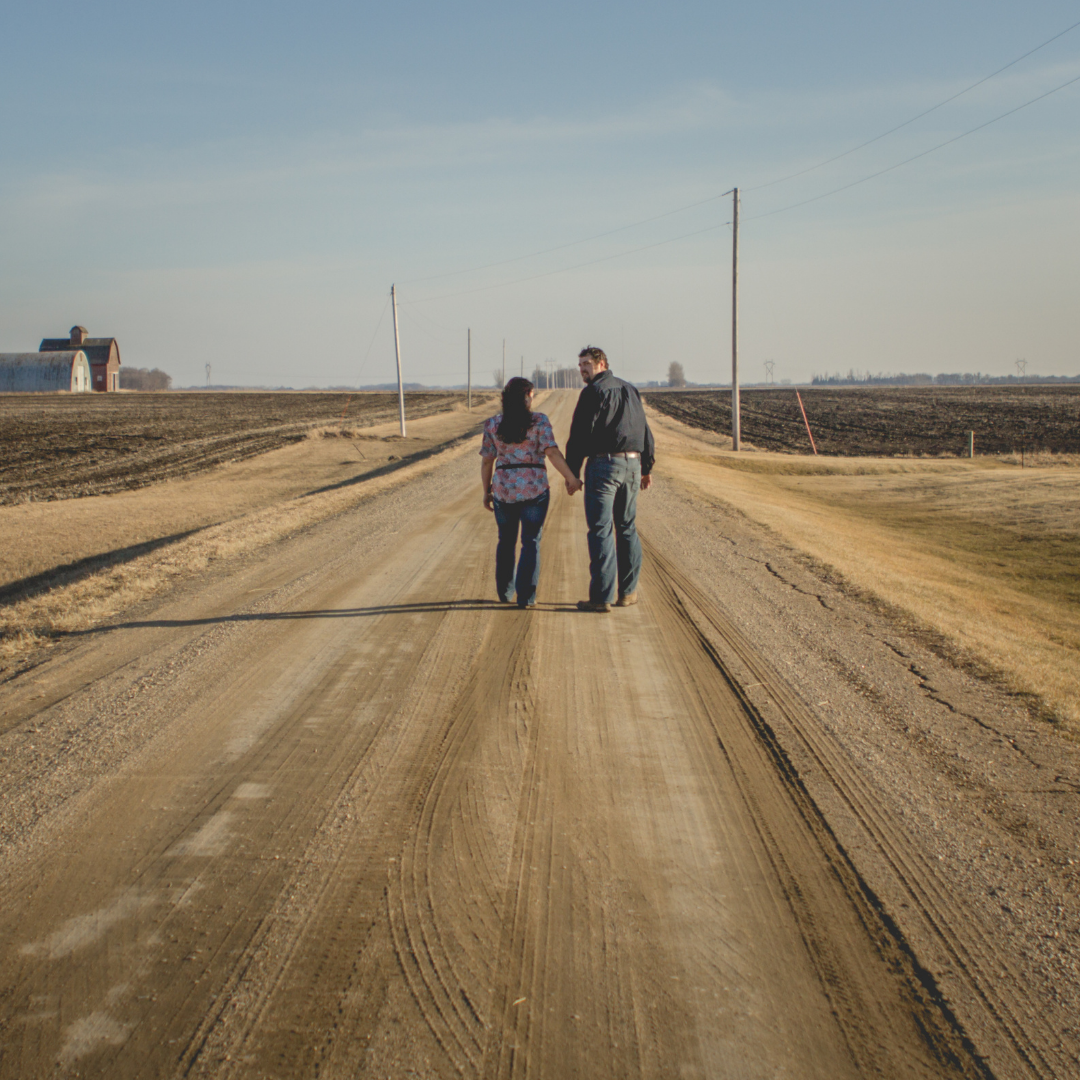 man and woman walking along a dirt road