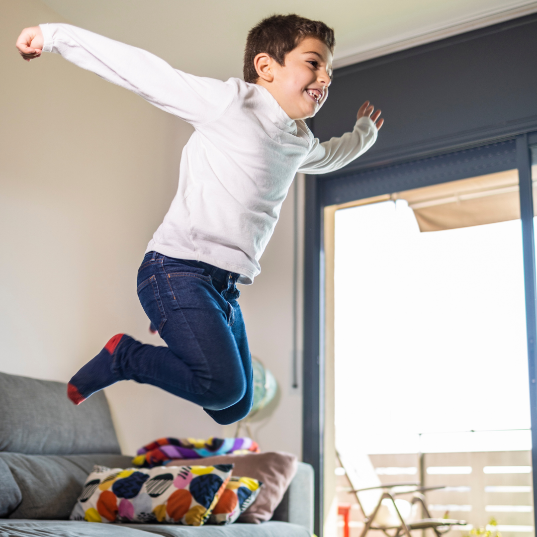 little boy jumping off the couch