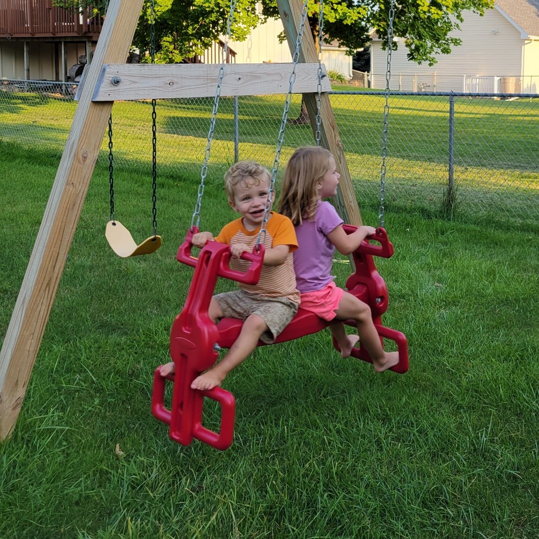 2 small kids on a swing