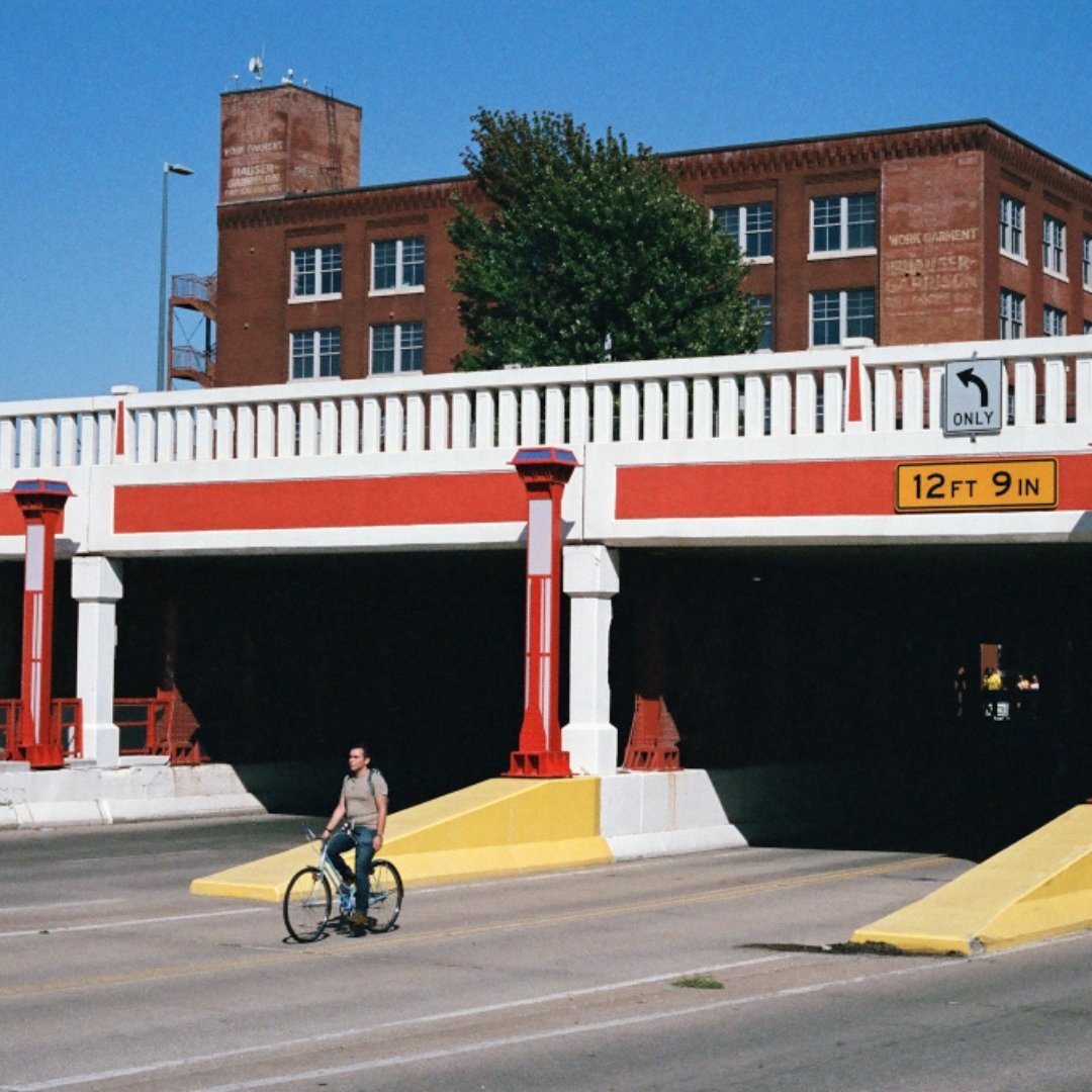 man on bicycle emerging from under a bridge
