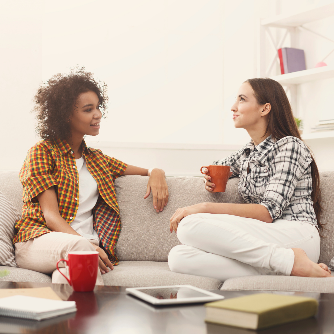 2 women on a couch, talking