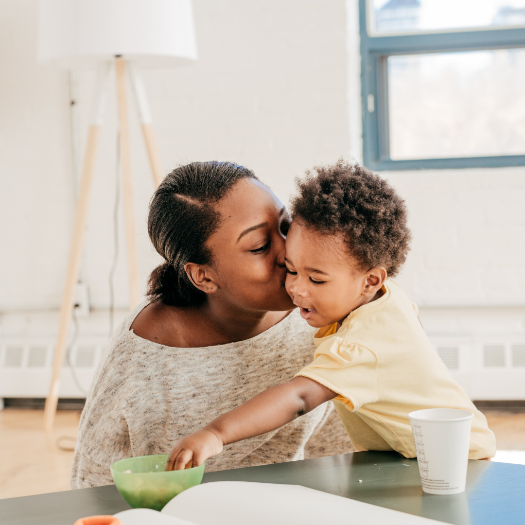 mom kissing a small toddler