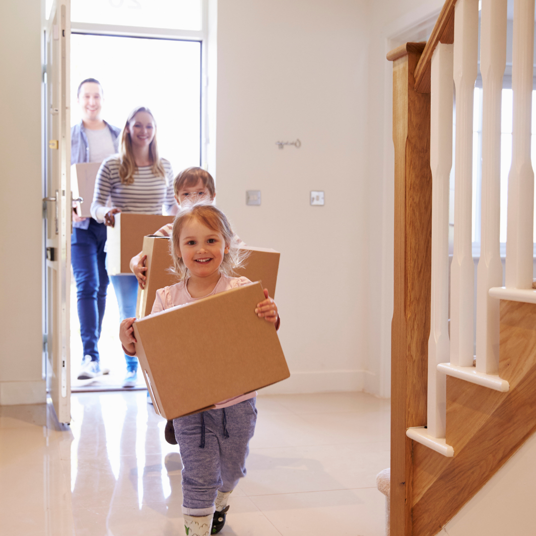 family carrying moving boxes