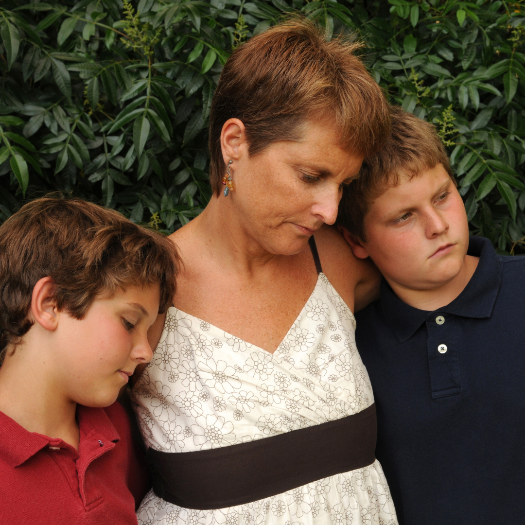 woman comforting 2 boys