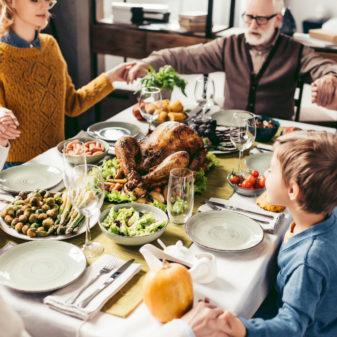 family praying around the Thanksgiving table