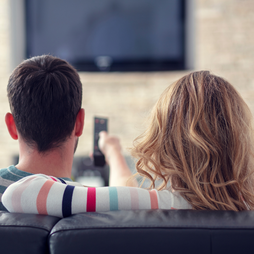 man and woman watching TV together