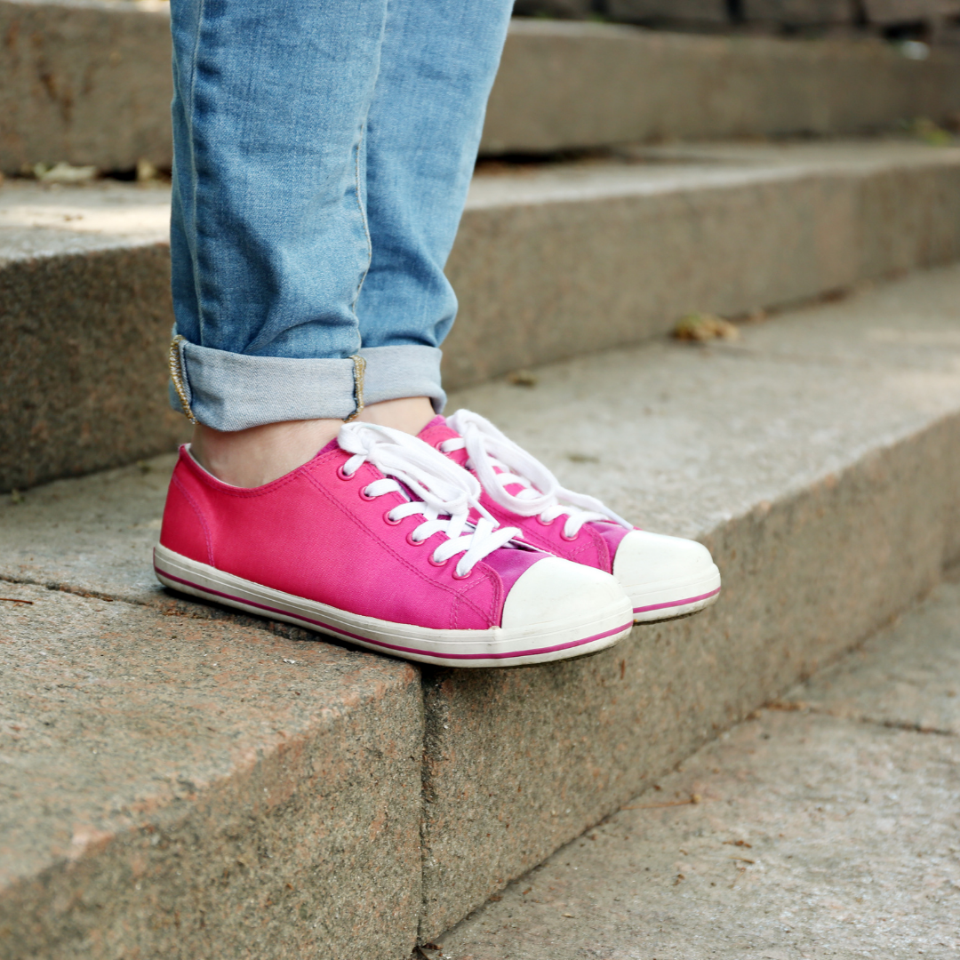 woman in pink Converse standing on stairs