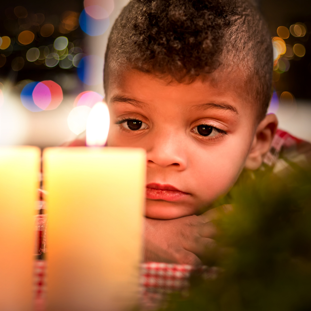 sad child looking at candles