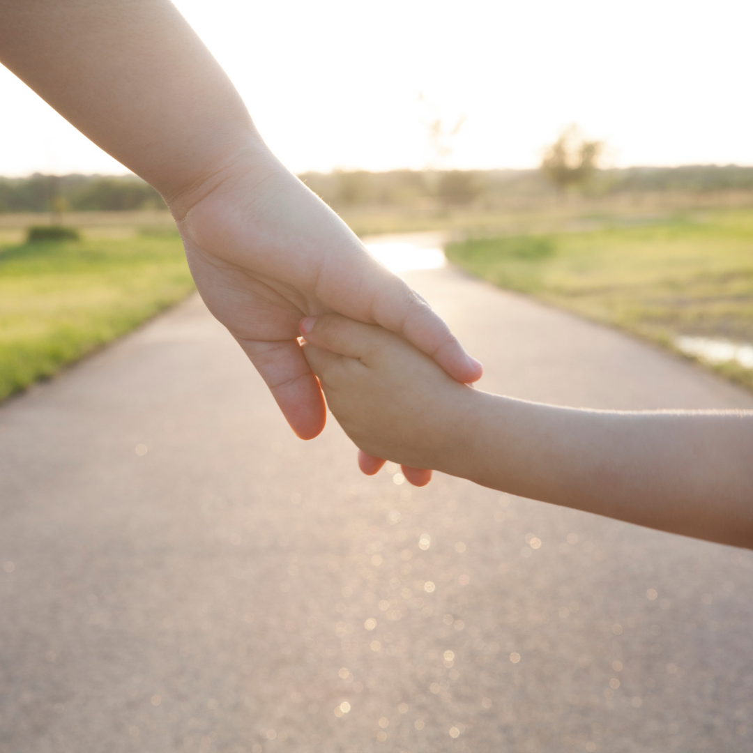 child holding adult's hand