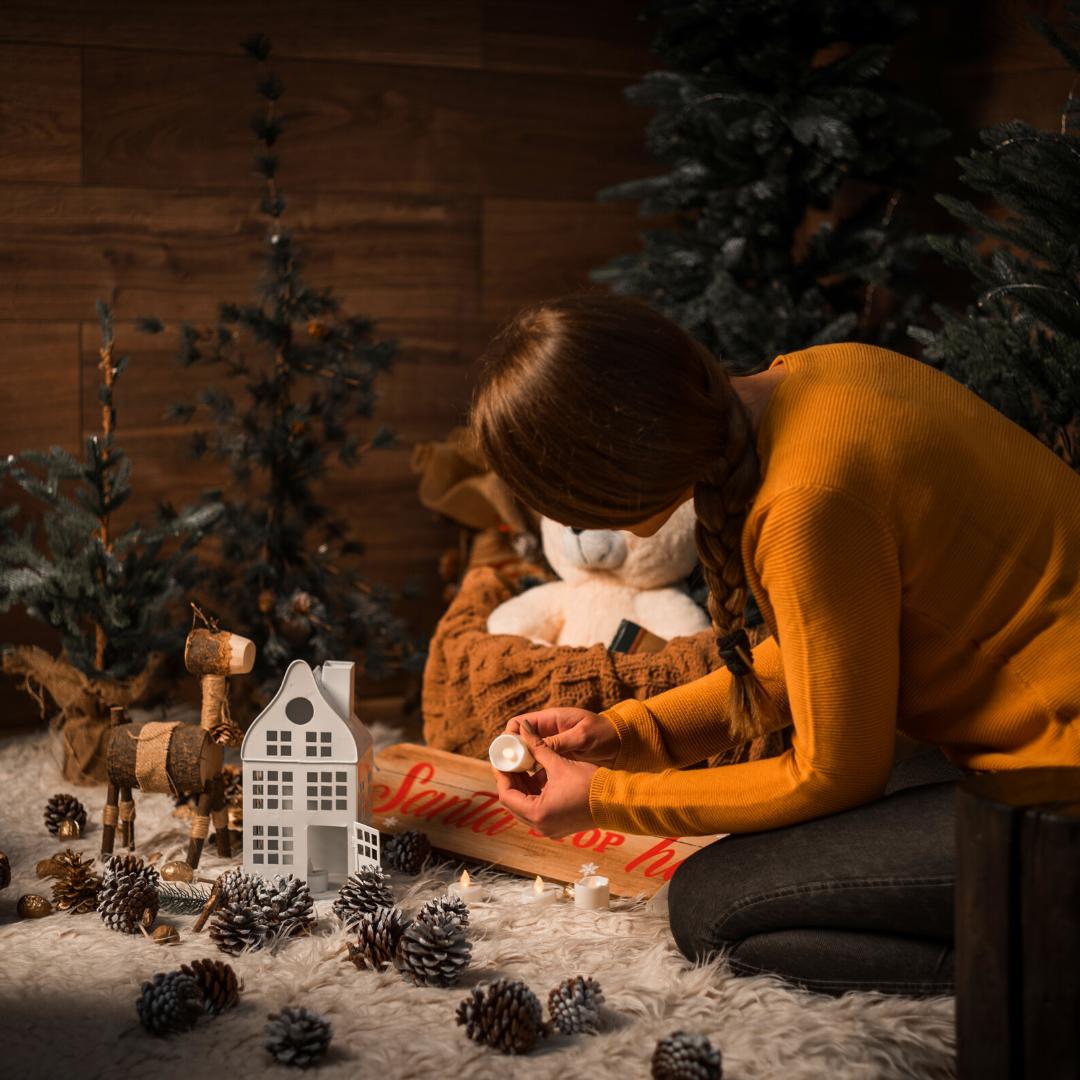 woman setting out rustic Christmas village decorations