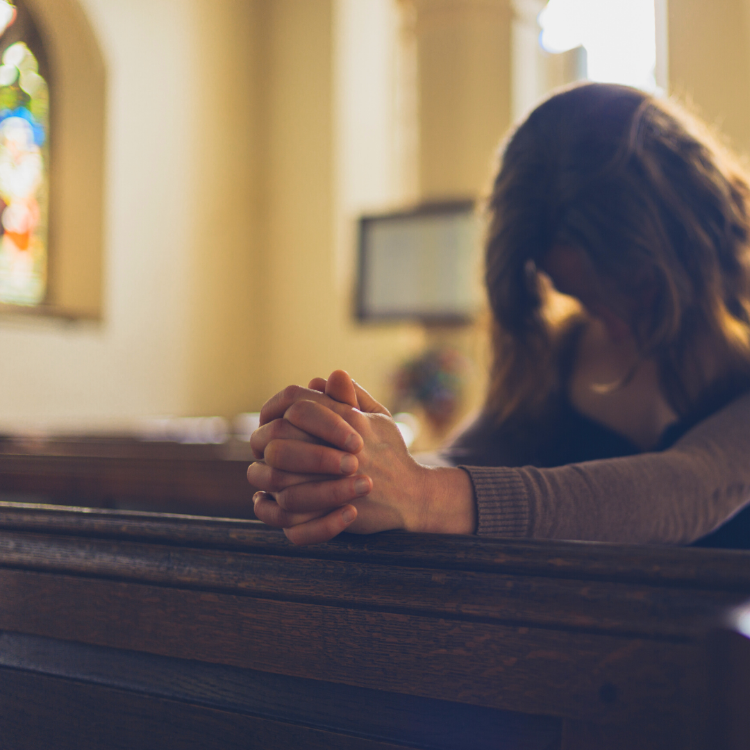 woman praying alone in church