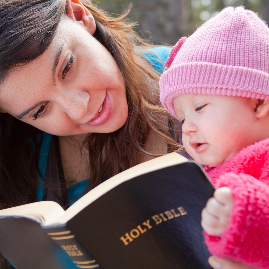 mom and baby looking at a Bible