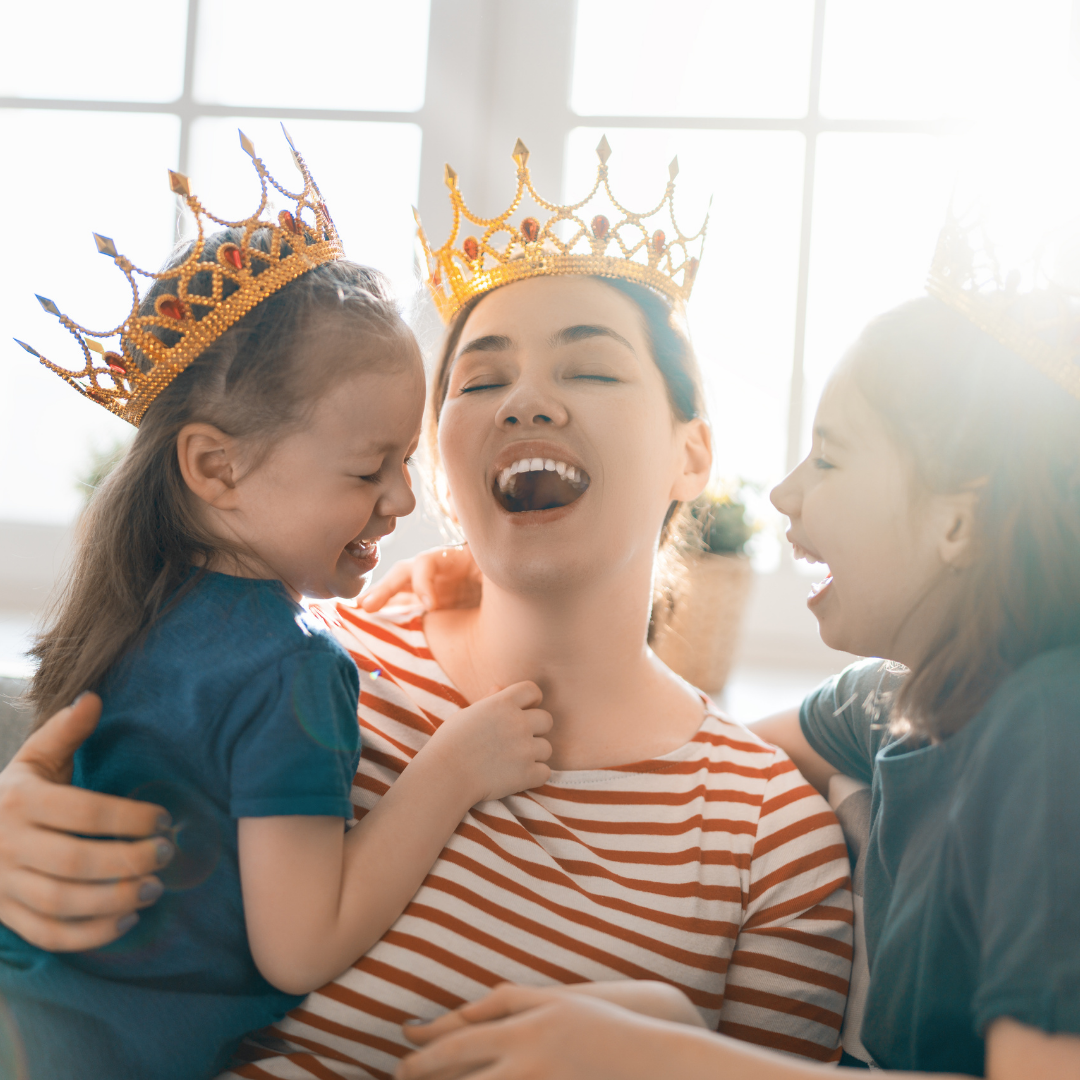 mom and girls wearing crowns and laughing