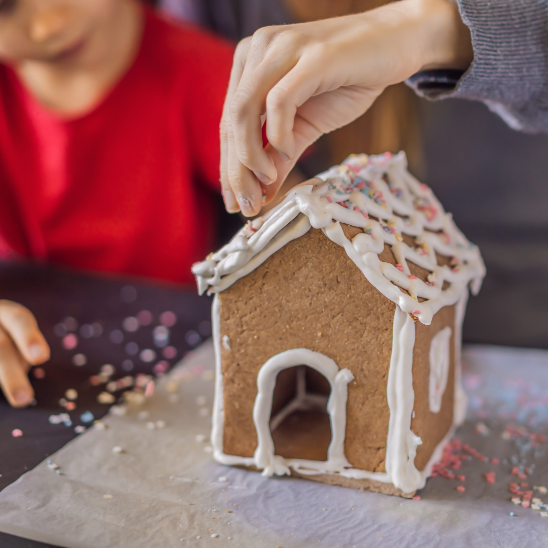 mom and child decorating gingerbread house