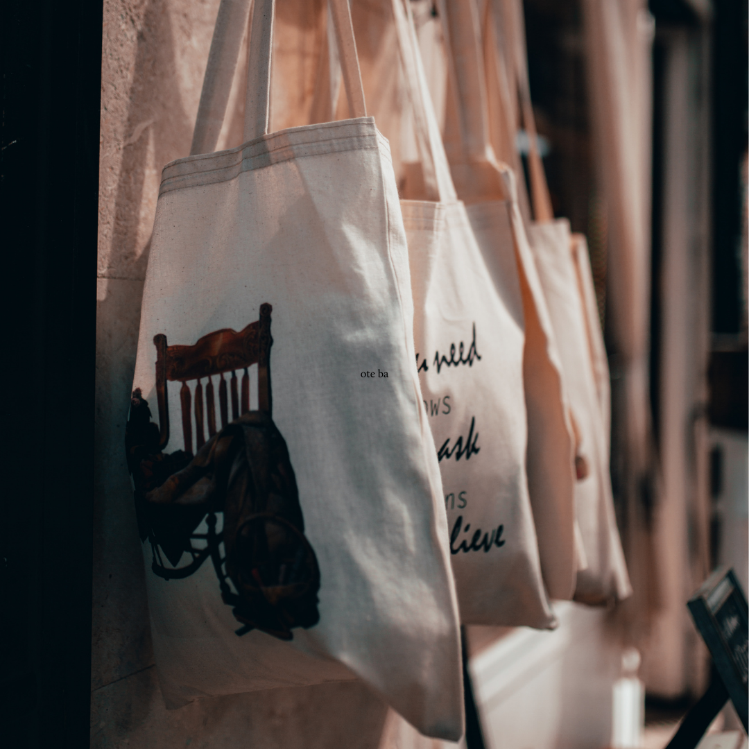 full tote bags hanging along a wall