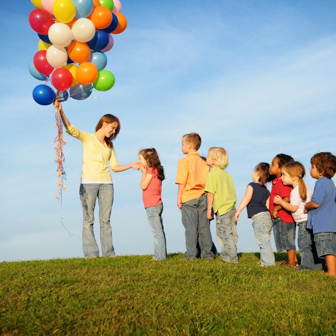 children waiting on a line to get a balloon