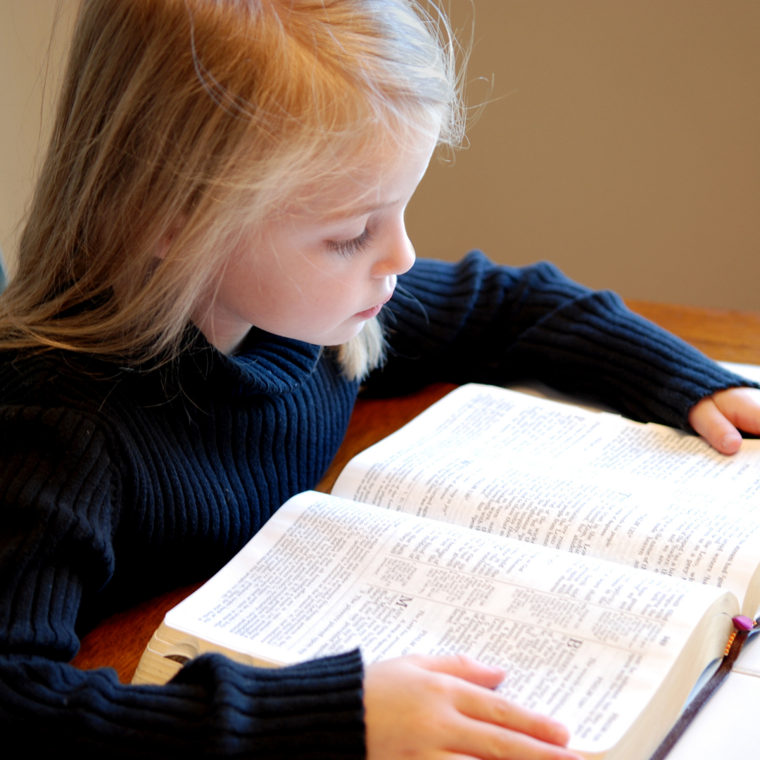 little girl reading a Bible