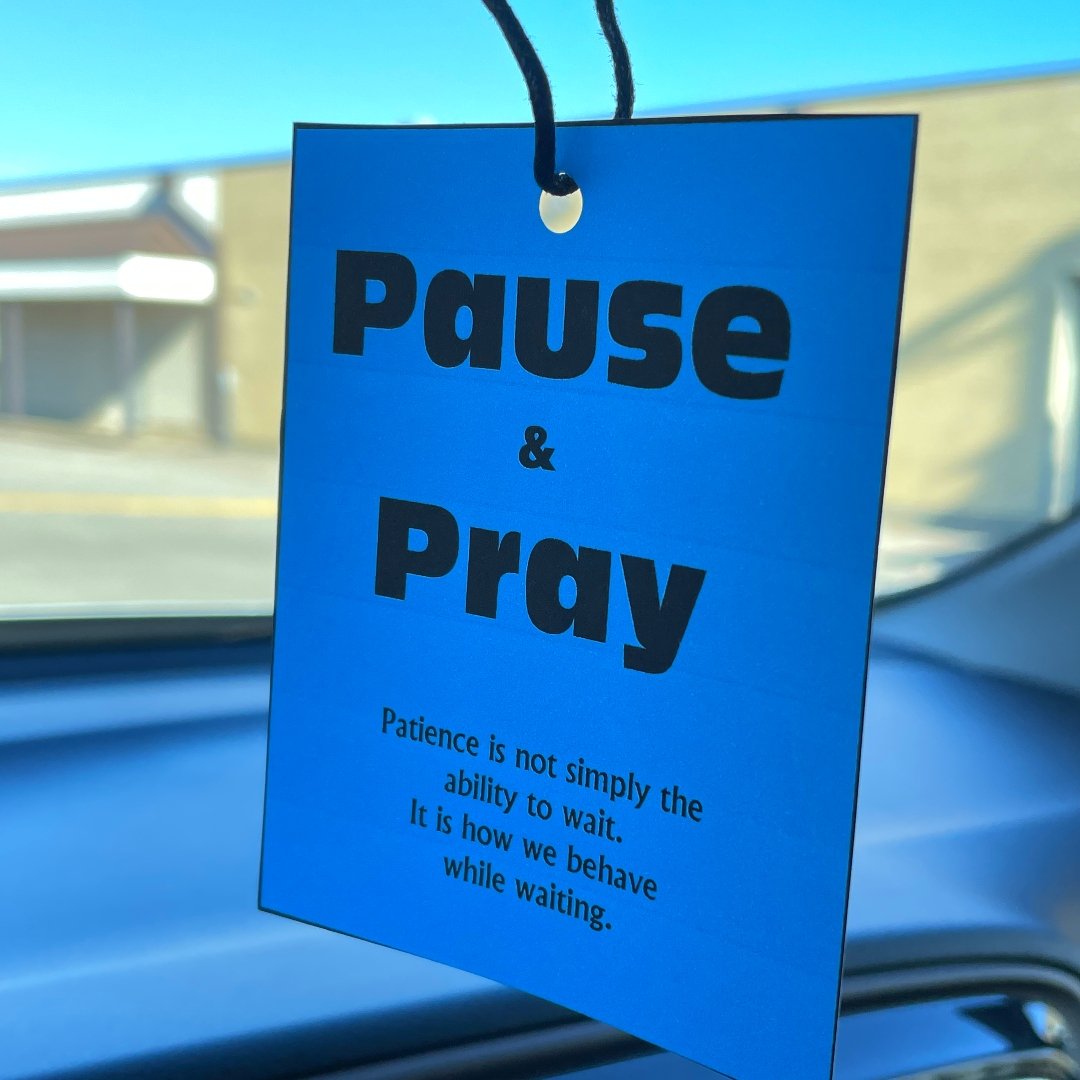 pause and pray sign hanging from car mirror