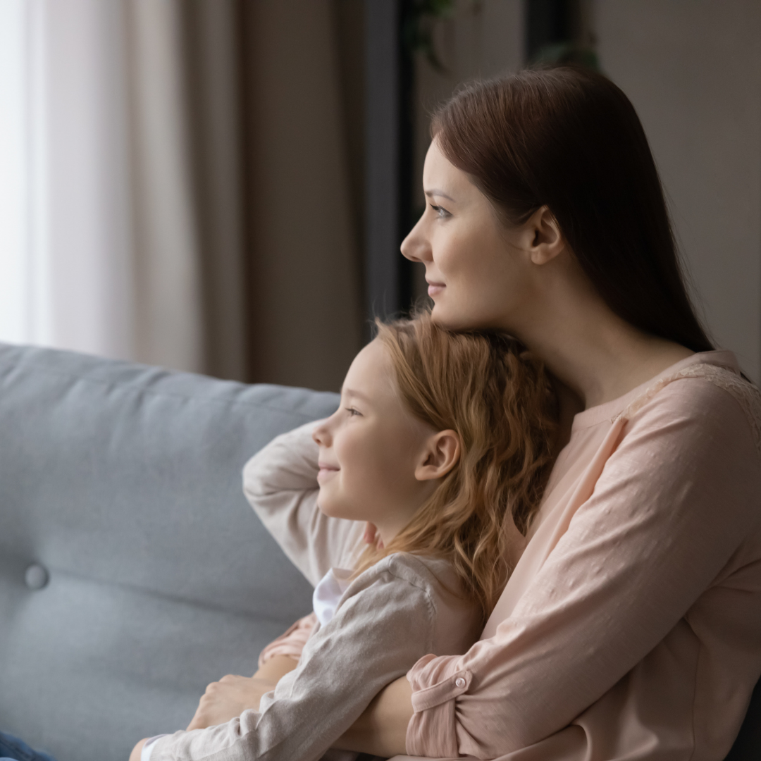 mom and daughter snuggling on the couch