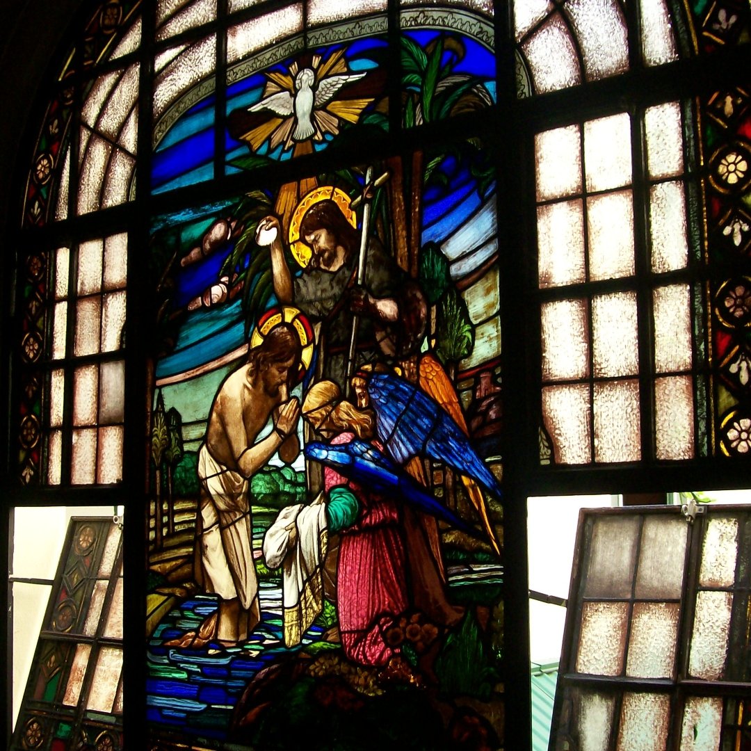 stained glass window depicting the Baptism of the Lord