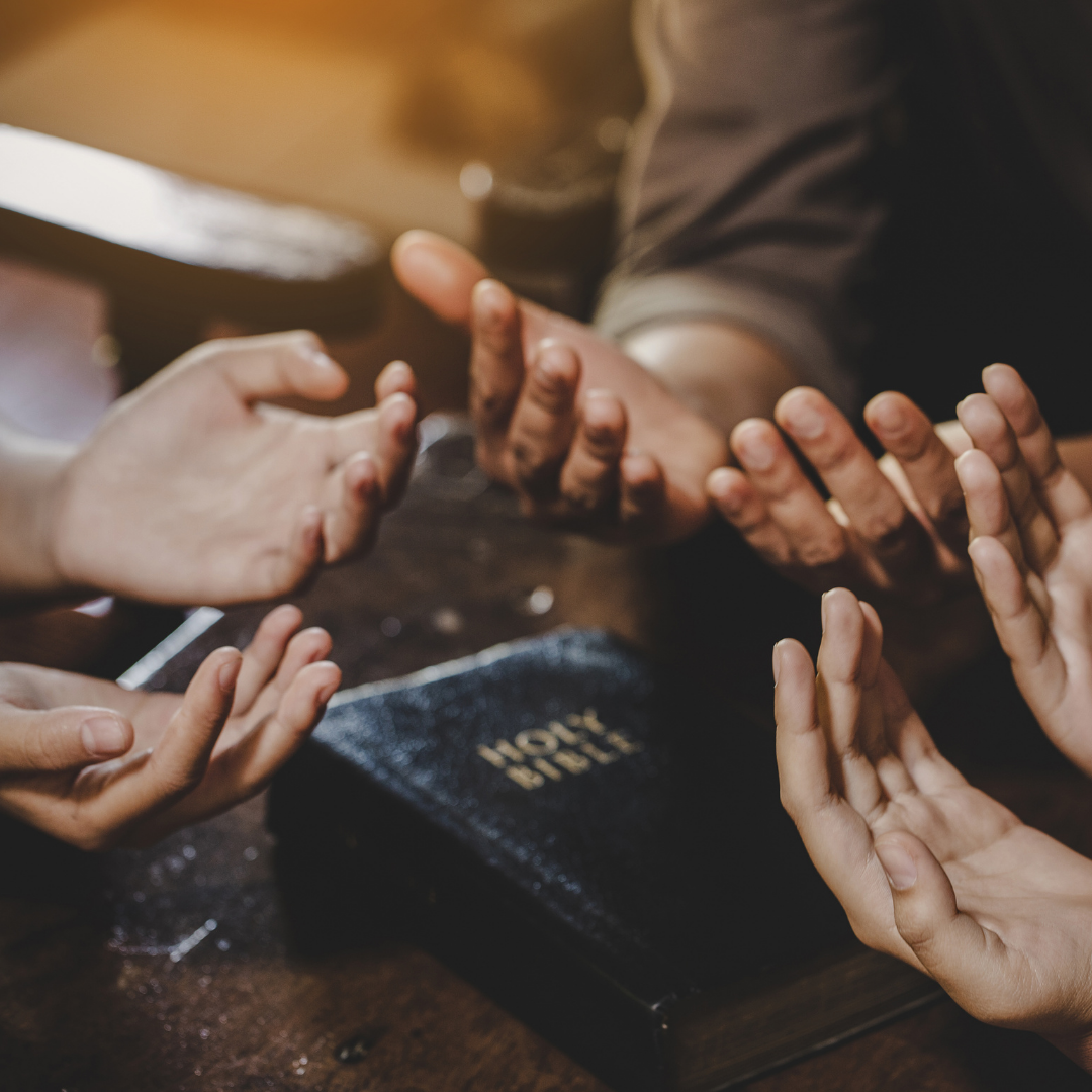 family praying with a Bible nearby