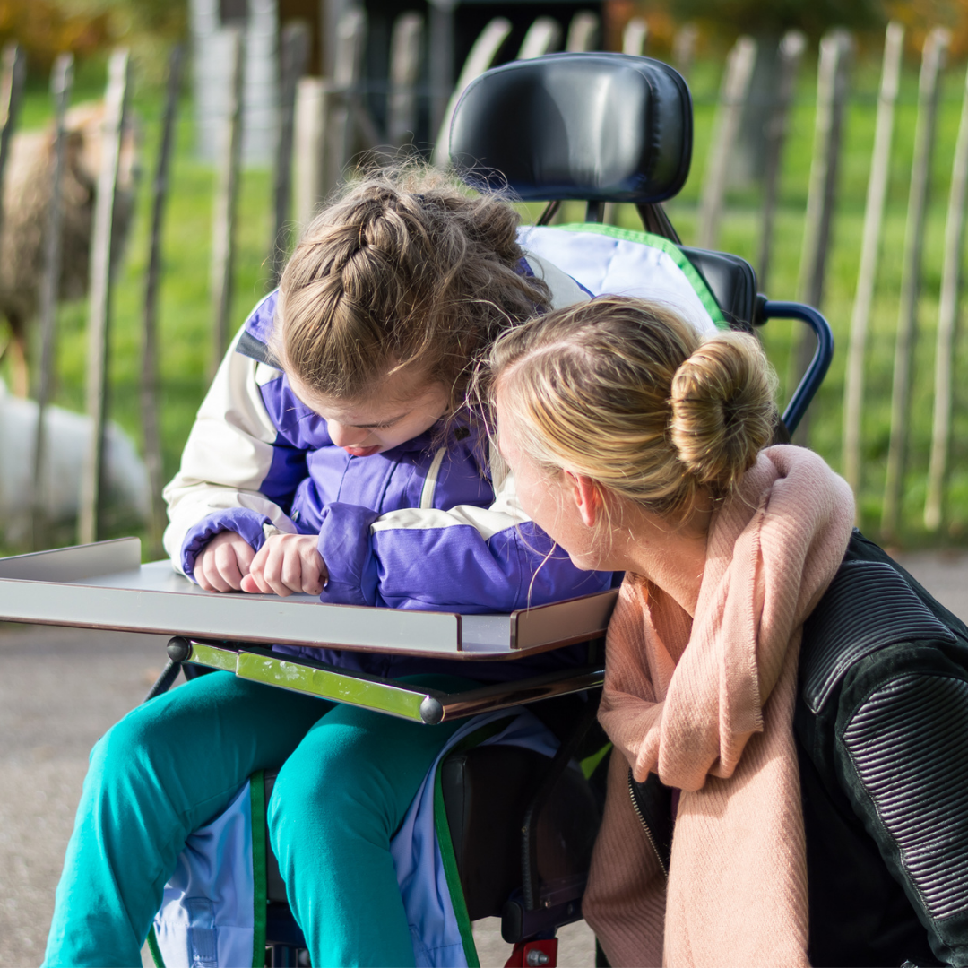 woman talking with a girl in wheelchair