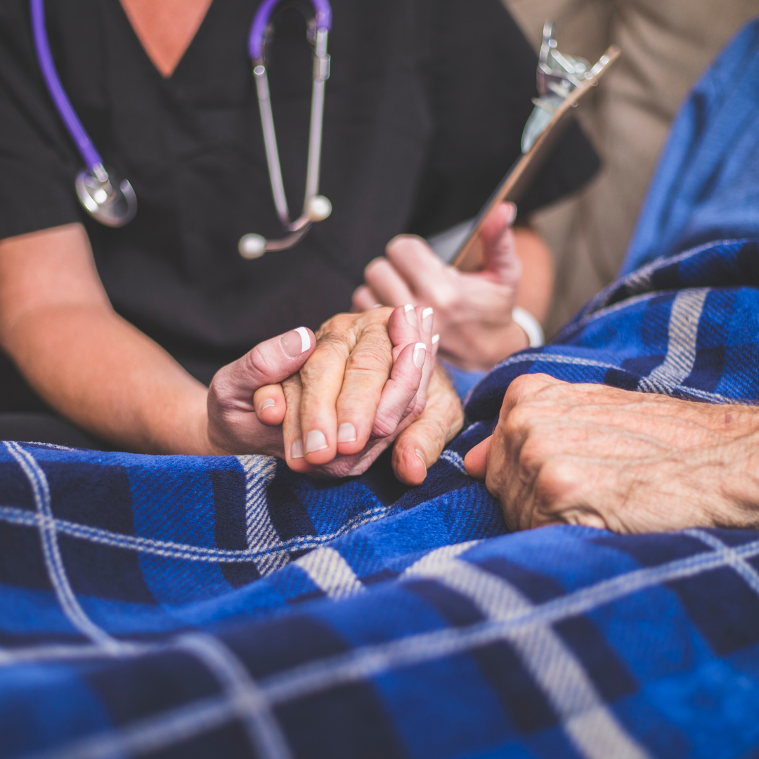 nurse holding hand of elderly patient