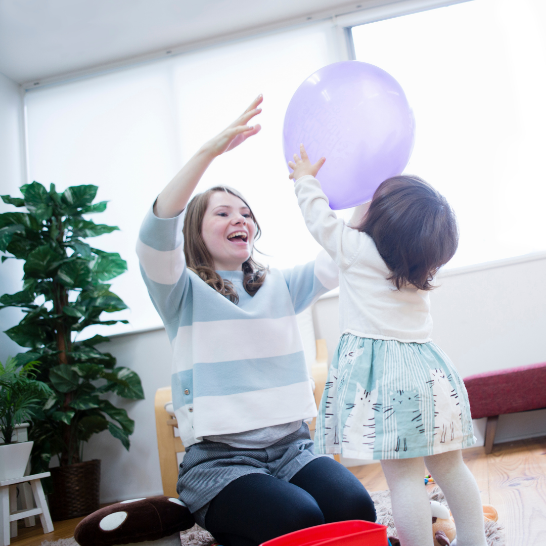mom and child playing with a balloon