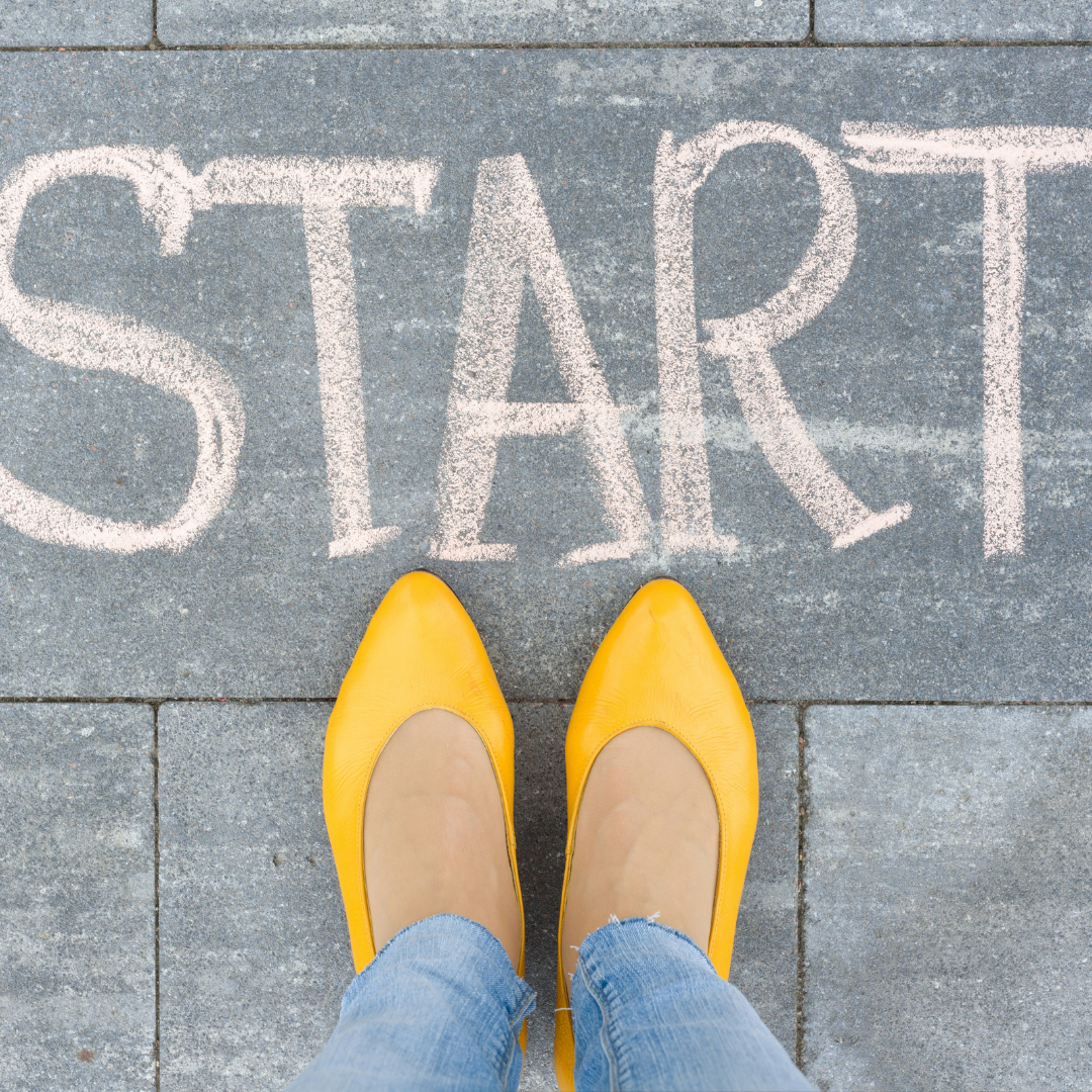 woman in yellow pumps standing on slate sidewalk with word "START" written on it