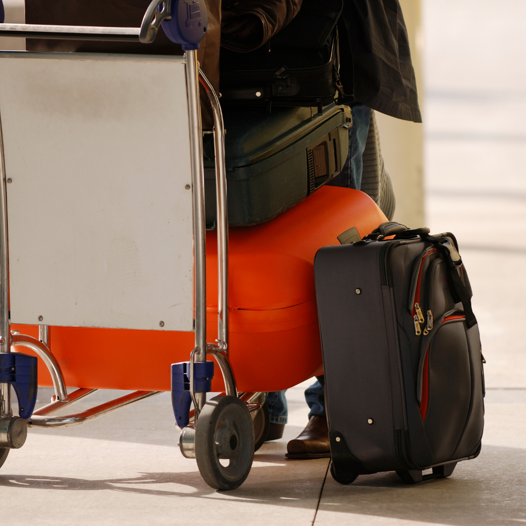 suitcases piled on luggage cart