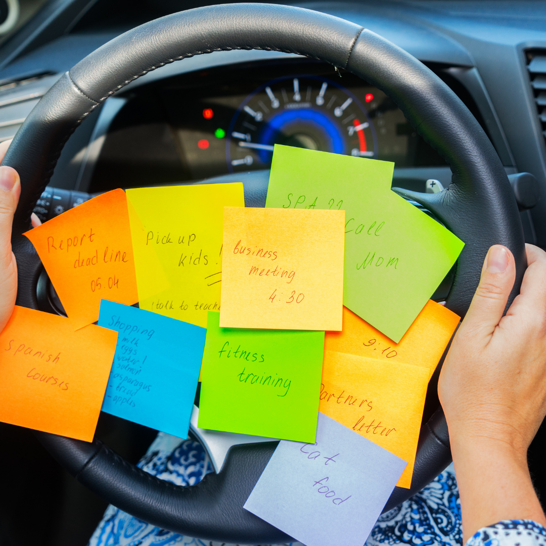 woman driving a car with multiple post-it notes on steering wheel