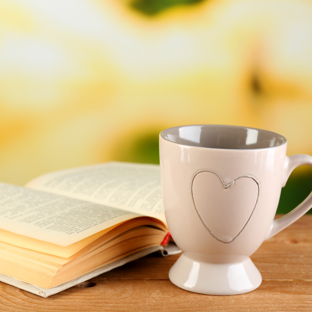 open book next to heart mug