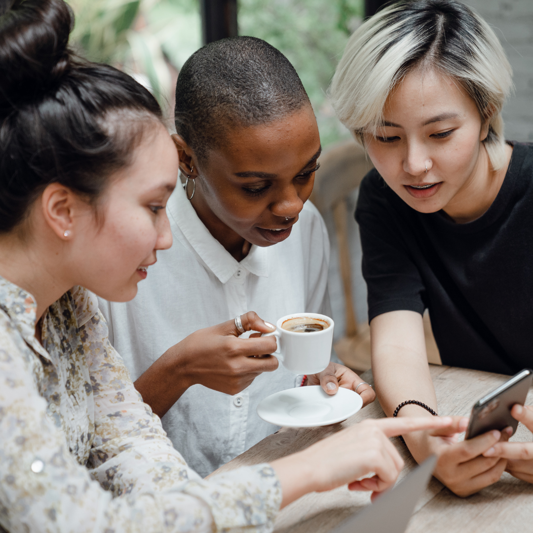women in a cafe looking at mobile phone