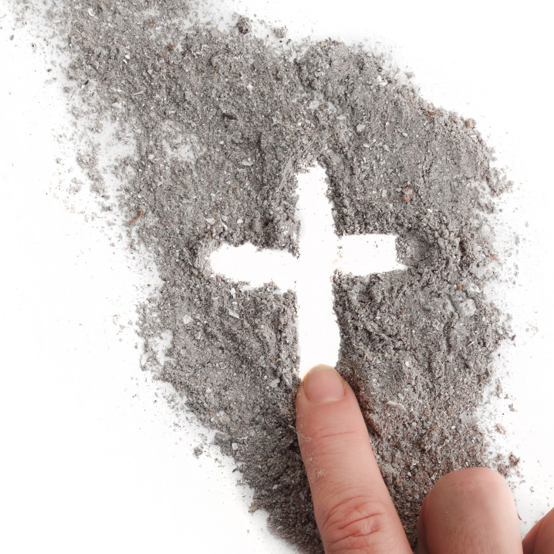 finger drawing a cross in ashes