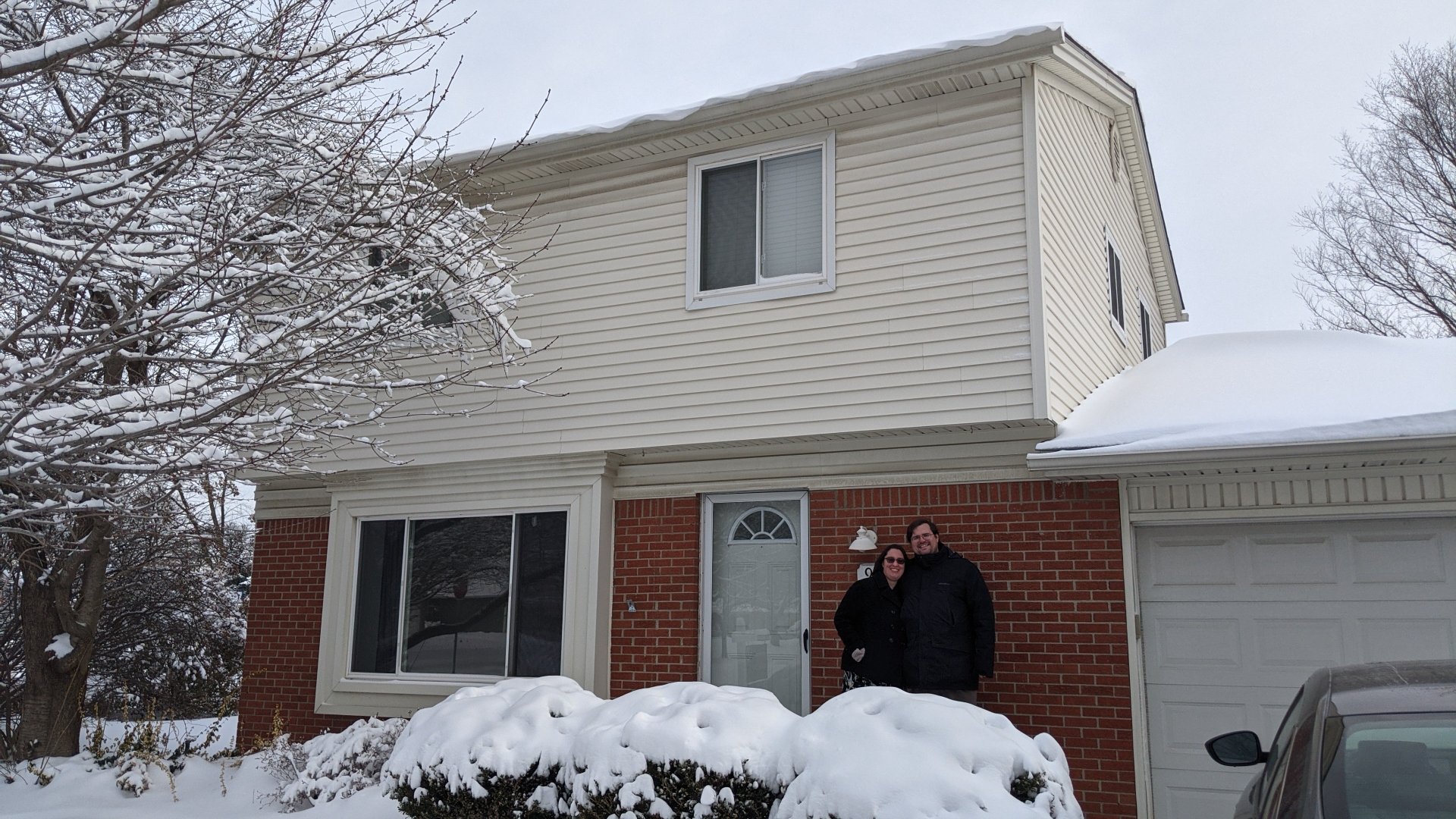 couple in front of home in winter
