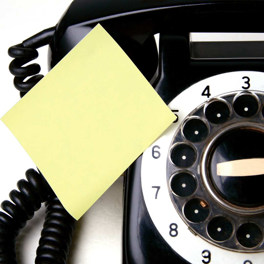 post-it note on black rotary phone