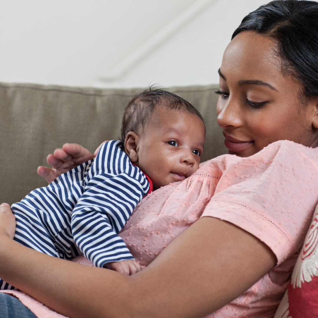 mom holding baby on a couch