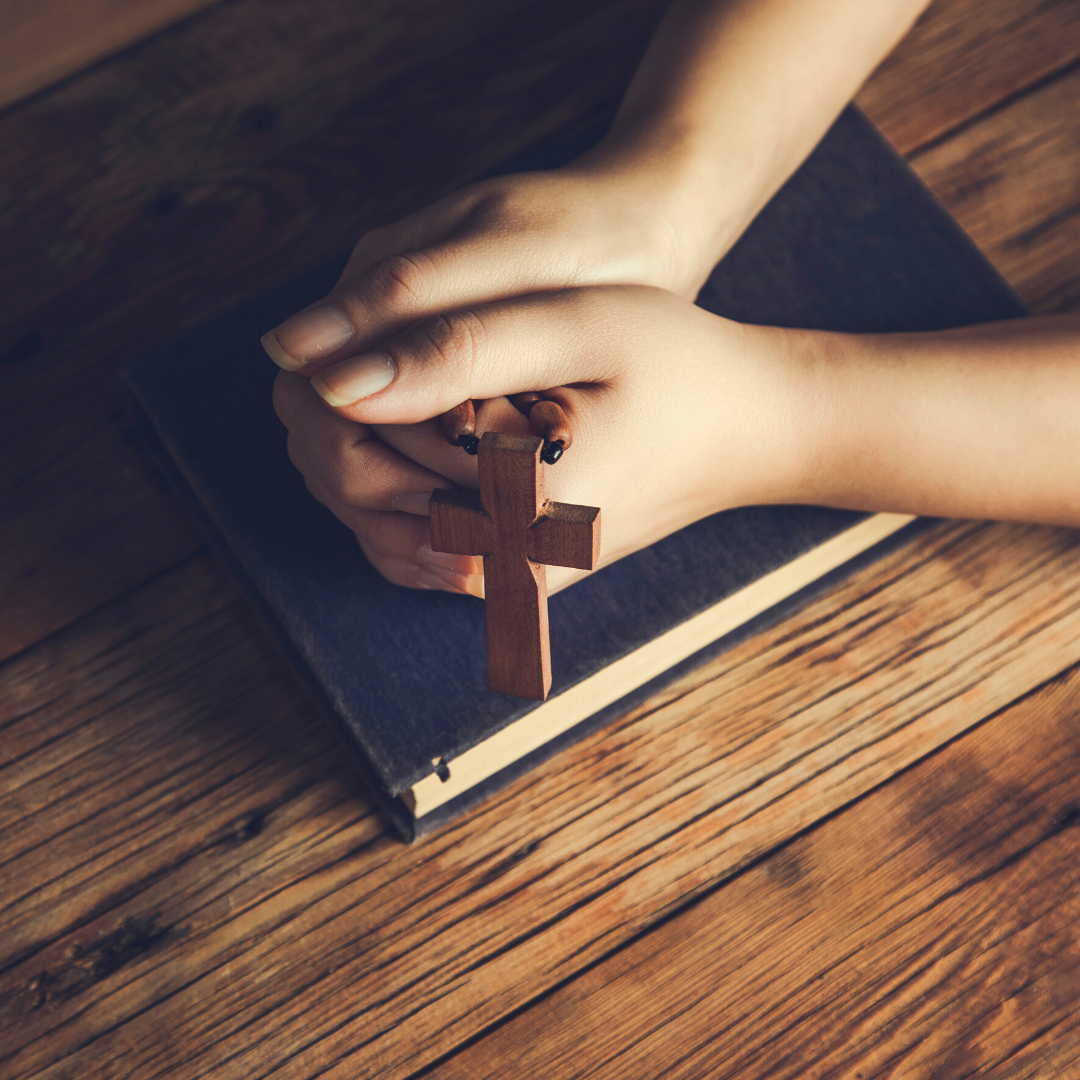 Bible, 2 hands holding a Rosary with large cross
