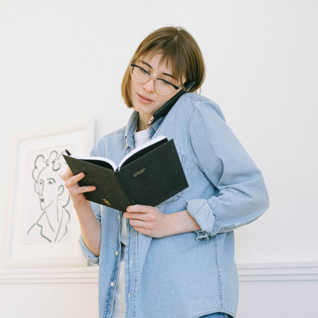 woman juggling phone and appointment book