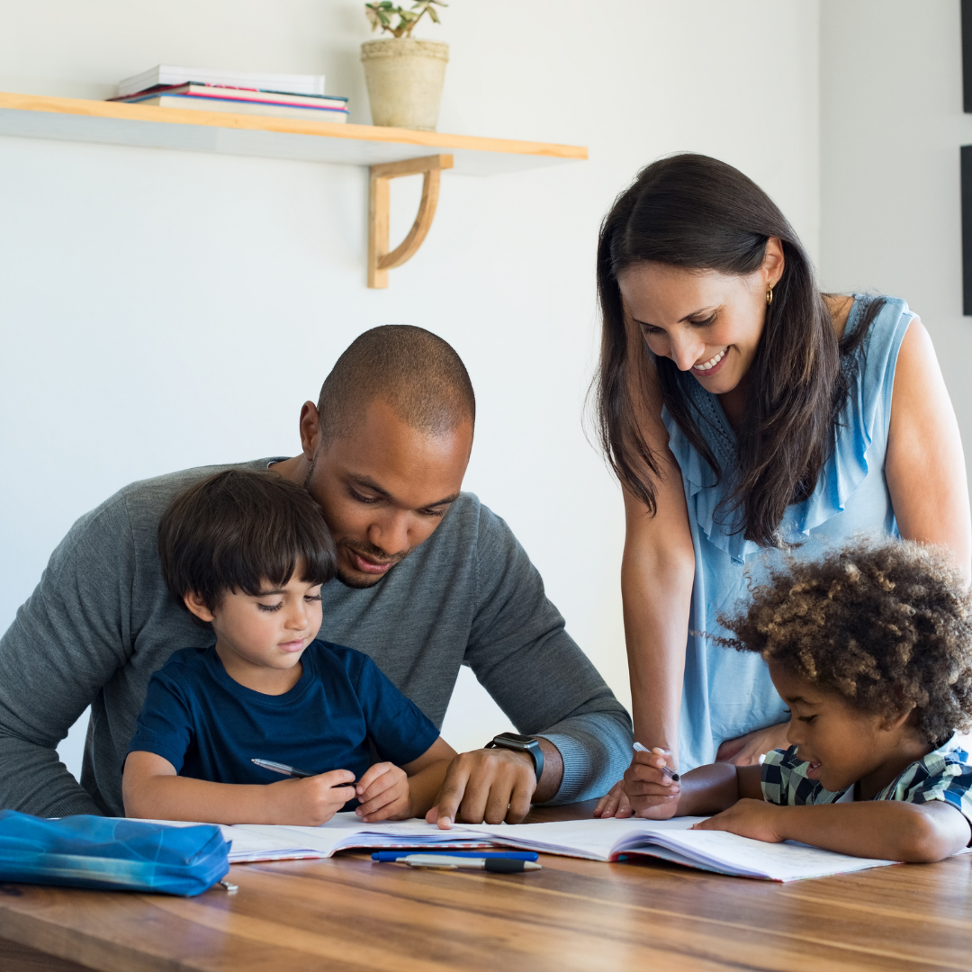 biracial couple with 2 children, looking at schoolbooks