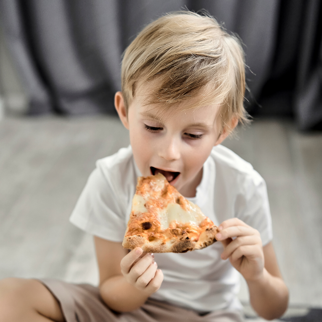 little boy eating pizza