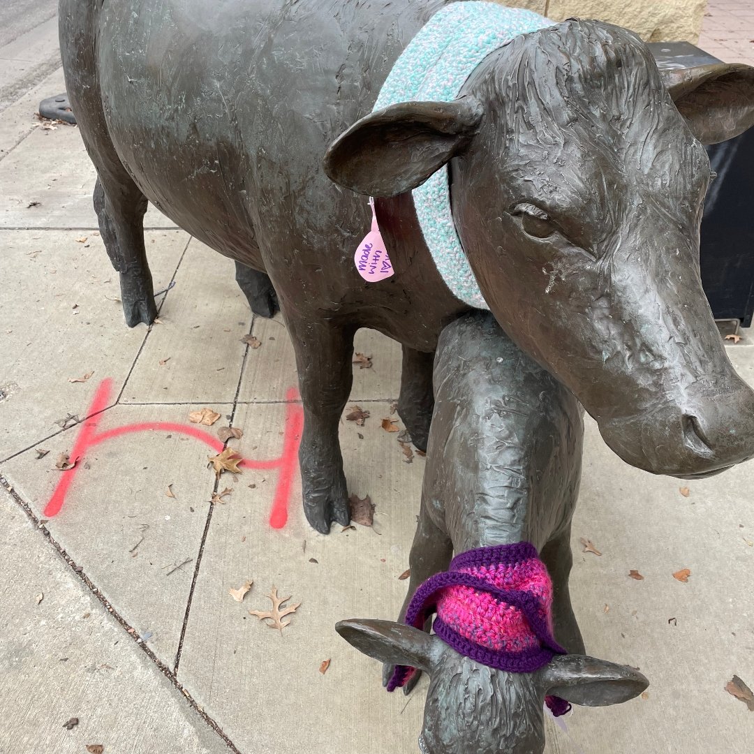 sculpture of 2 animals with scarves wrapped around their necks