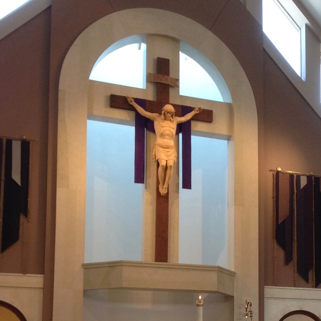 wooden cross in a church in front of a window