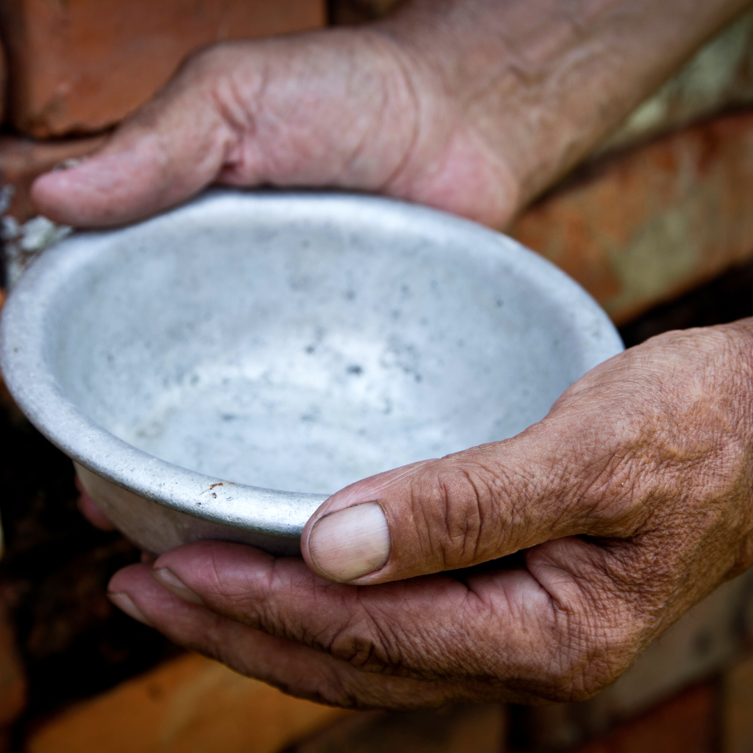 old person's hands holding an empty metal bowl